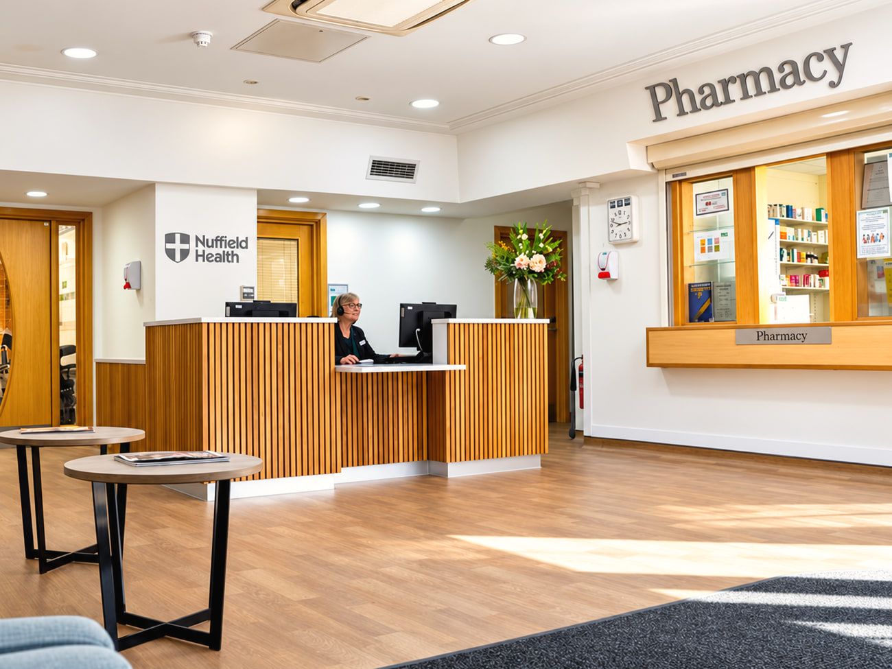 The reception desk at Nuffield Health Parkside Hospital, with wooden panelling and a waiting area in front.